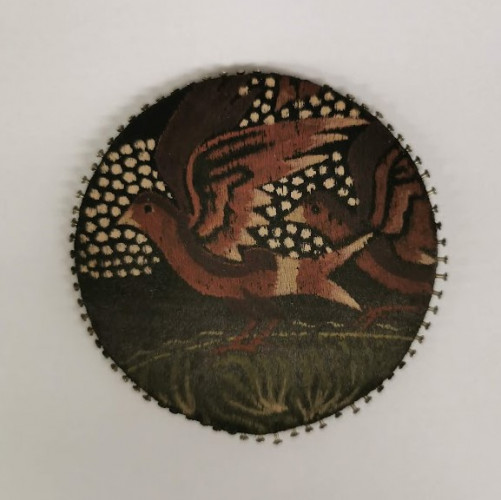 Black circle showing birds against a spotted background